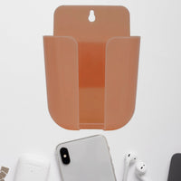 Wall mounted phone holder with a charging port in a modern living space.