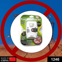 A single white pest repelling aid in its clear plastic and green cardboard packaging, against a blurry background.