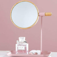 Round tabletop makeup mirror with wooden finish frame on vanity table