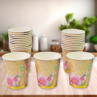 A stack of mixed design disposable paper cups ready for use at an Indian gathering.