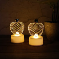 Three apple LED tealight candles creating a warm, ambient glow in a room.