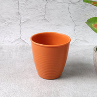 Plastic small drinking glass filled with hot tea on table