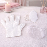 Disposable hygiene safety kit set including gloves, face mask, and shower cap in protective packaging