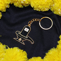 Hand holding golden Shivling keychain showing its size and golden finish