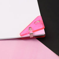 Close-up of durable triangle paper clip securing paper corner