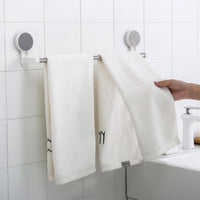 Towel rack bar installed on bathroom wall using adhesive mount