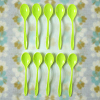 A single reusable plastic spoon placed elegantly on a table setting.