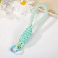 Various uses of the multipurpose strap, including attaching to keys and a camera, showcasing versatility.