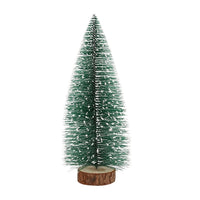 Decorative green artificial fir tree with snow effect standing on wooden base