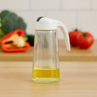 Glass oil bottle dispenser showing measuring marks and leak-proof spout