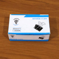 Multiple heavy duty black metal binder clips arranged for office use