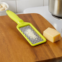 An overhead view of the CookAura grater, highlighting its full length and stainless steel blade.