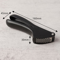 Angled view of a manual garlic press crusher tool showing construction