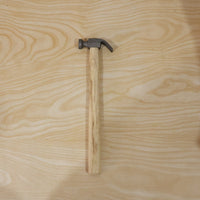 Person using claw hammer to drive a nail in carpentry