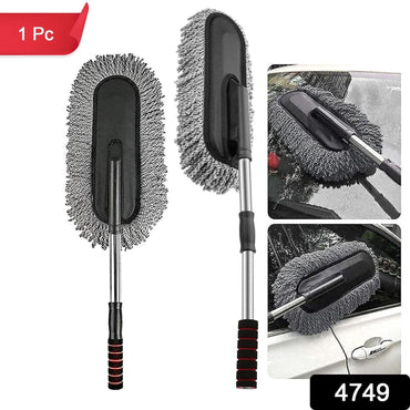Person using the retractable car duster to clean a car's exterior.