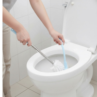 The toilet brush with holder in a clean, minimalist bathroom setting.