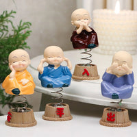 Baby monk figurines displayed on a car dashboard