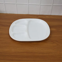 Plastic compartment plate in use with Indian meal served in sections