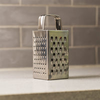 Close-up of multi-sided stainless steel grater and slicer tool