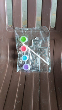 Assorted acrylic paint tubes and a plastic stencil for creative projects.