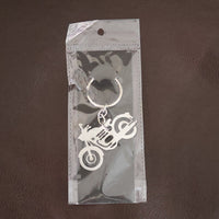 Lifestyle shot of a motorcycle silhouette metal keychain attached to a set of keys.