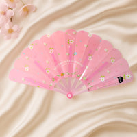 Floral hand fan resting elegantly on a table