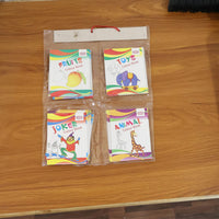 Child's hand holding a colouring book from educational set
