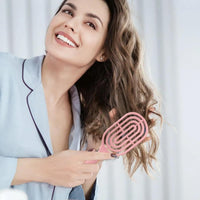 Side profile of the curved hair brush showing its unique shape.