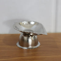 Aromatic incense and diya shown on elegant stainless steel stand