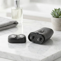 Portable electric shaver in hand showing compact size and sleek design