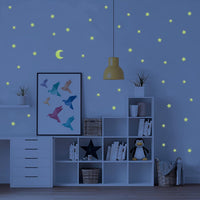 Close-up view of a luminous star wall decal, showing its bright glow in a dark room.