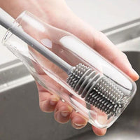 A bottle cleaning brush effectively cleaning the inside of a tall water bottle.