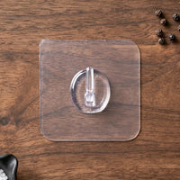Self-adhesive clear wall hook in use for organizing small items