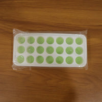 Close-up of the plastic ice cube tray's round molds, ready for filling.