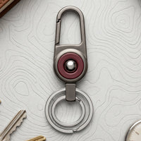 Durable metal key holder with dual rings and locking clip attached to a backpack