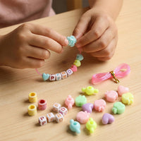 Close-up of colourful beads and elastic thread in kids jewellery kit
