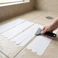 Safe bathroom surfaces improved by transparent anti-slip strips