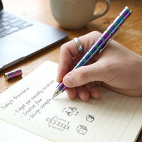 Hand demonstrating the fidget spinner function of the magnetic metal pen.