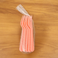 Pink plastic fork spoon being held, ready for use.