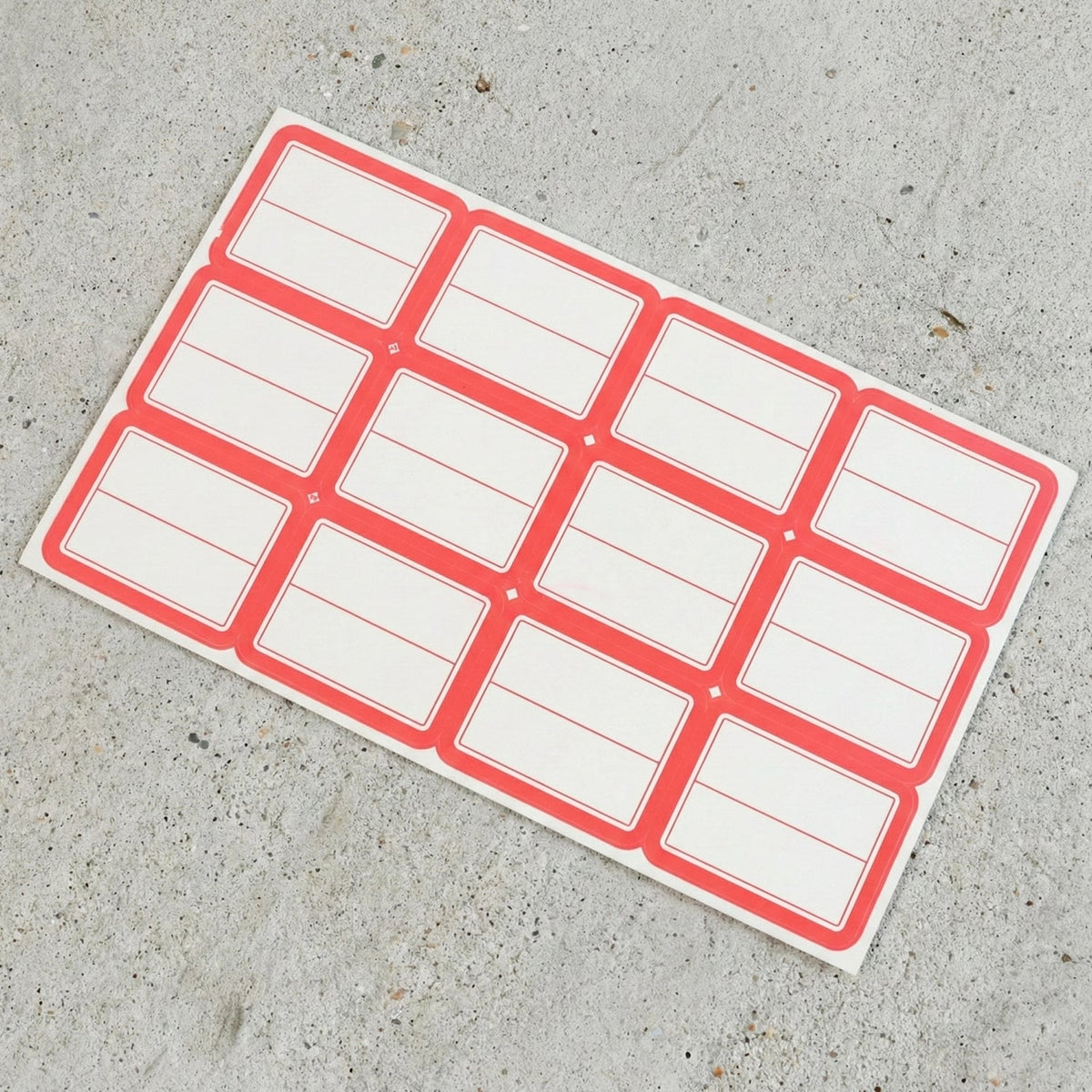 Close-up view of red and white rectangular self-adhesive label stickers