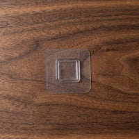 Close-up of a transparent wall sticker hook for discreet storage.
