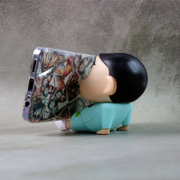 Mobile phone stand featuring a cartoon figurine design on desk