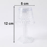Small crystal table lamp creating a warm, ambient glow in a dark room.